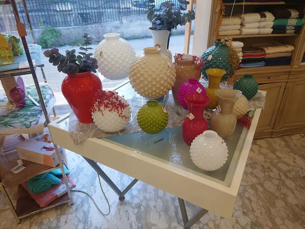 Vasi colorati esposti su un tavolo del negozio